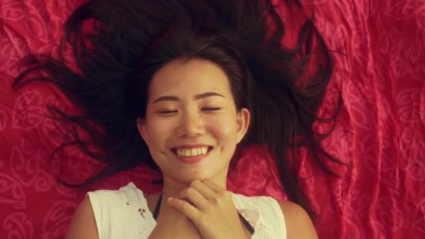 慢动作高角镜头射向年轻美丽而快乐的亚裔中国女人 平躺在沙隆脸上 笑容满面 心情舒畅 举止甜美 有着美感和时尚气息 — 图库视频影像