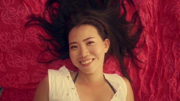 慢动作高角镜头射向年轻美丽而快乐的亚裔中国女人 平躺在沙隆脸上 笑容满面 心情舒畅 举止甜美 有着美感和时尚气息 — 图库视频影像