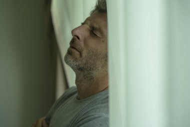 Orta yaşlı bir adamın evde karamsar bir portresi. Yatak odasının penceresinde hüzünlü ve depresif bir şekilde duruyor. Evde endişeli ve bunalımda.