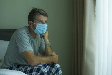 Virüs salgını. Tıbbi maske takan hasta bir adamın dramatik portresi. Koronavirüsten korkmuş ve endişeli. 