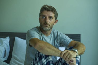 Çekici, korkmuş ve depresyonda olan 40 'lı yaşlarda pijamalı bir adamın dramatik portresi virüs karantinası sırasında endişe ve depresyon sorunu yaşıyor.