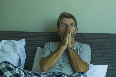 Çekici, korkmuş ve depresyonda olan 40 'lı yaşlarda pijamalı bir adamın dramatik portresi virüs karantinası sırasında endişe ve depresyon sorunu yaşıyor.