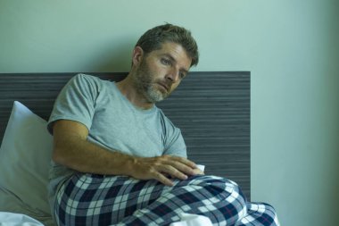 Çekici, korkmuş ve depresyonda olan 40 'lı yaşlarda pijamalı bir adamın dramatik portresi virüs karantinası sırasında endişe ve depresyon sorunu yaşıyor.