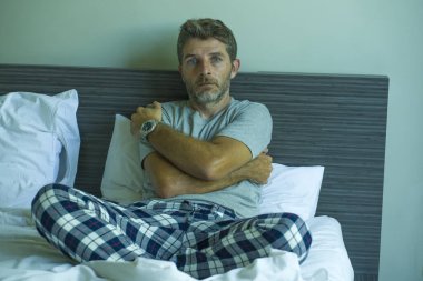 Çekici, korkmuş ve depresyonda olan 40 'lı yaşlarda pijamalı bir adamın dramatik portresi virüs karantinası sırasında endişe ve depresyon sorunu yaşıyor.
