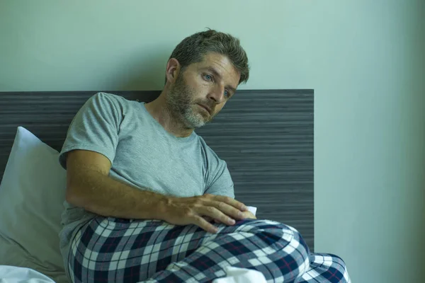 パジャマ気分でベッドの上で40代の男を怖がらせうつ状態にする劇的なポートレートウイルスの隔離ホームロックダウン中に不安やうつ病の問題に苦しんで — ストック写真