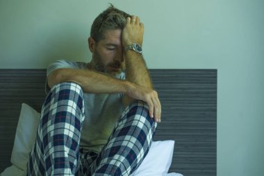 Çekici, korkmuş ve depresyonda olan 40 'lı yaşlarda pijamalı bir adamın dramatik portresi virüs karantinası sırasında endişe ve depresyon sorunu yaşıyor.