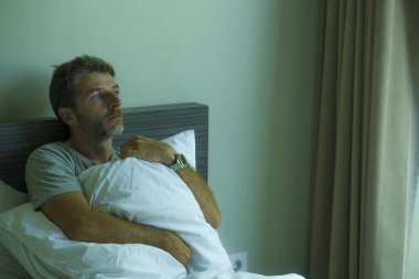 Çekici, korkmuş ve depresyonda olan 40 'lı yaşlarda pijamalı bir adamın dramatik portresi virüs karantinası sırasında endişe ve depresyon sorunu yaşıyor.