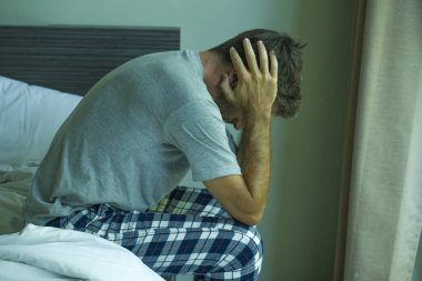 Çekici, korkmuş ve depresyonda olan 40 'lı yaşlarda pijamalı bir adamın dramatik portresi virüs karantinası sırasında endişe ve depresyon sorunu yaşıyor.