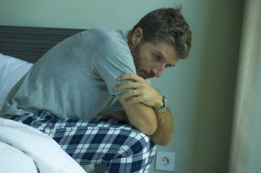 Çekici, korkmuş ve depresyonda olan 40 'lı yaşlarda pijamalı bir adamın dramatik portresi virüs karantinası sırasında endişe ve depresyon sorunu yaşıyor.