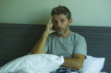 Çekici, korkmuş ve depresyonda olan 40 'lı yaşlarda pijamalı bir adamın dramatik portresi virüs karantinası sırasında endişe ve depresyon sorunu yaşıyor.