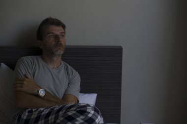 Çekici, korkmuş ve depresyonda olan 40 'lı yaşlarda pijamalı bir adamın dramatik portresi virüs karantinası sırasında endişe ve depresyon sorunu yaşıyor.