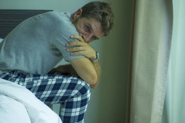 Çekici, korkmuş ve depresyonda olan 40 'lı yaşlarda pijamalı bir adamın dramatik portresi virüs karantinası sırasında endişe ve depresyon sorunu yaşıyor.