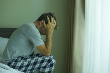 Çekici, korkmuş ve depresyonda olan 40 'lı yaşlarda pijamalı bir adamın dramatik portresi virüs karantinası sırasında endişe ve depresyon sorunu yaşıyor.