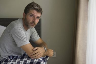 Çekici, korkmuş ve depresyonda olan 40 'lı yaşlarda pijamalı bir adamın dramatik portresi virüs karantinası sırasında endişe ve depresyon sorunu yaşıyor.