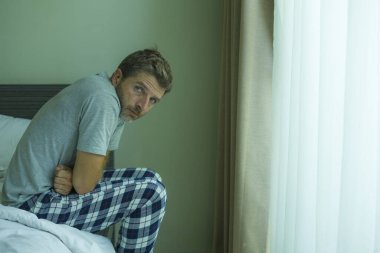 Çekici, korkmuş ve depresyonda olan 40 'lı yaşlarda pijamalı bir adamın dramatik portresi virüs karantinası sırasında endişe ve depresyon sorunu yaşıyor.