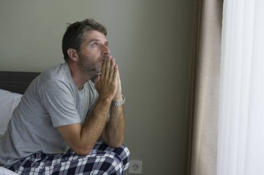 Çekici, korkmuş ve depresyonda olan 40 'lı yaşlarda pijamalı bir adamın dramatik portresi virüs karantinası sırasında endişe ve depresyon sorunu yaşıyor.