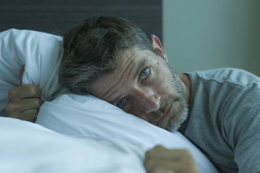 Çekici, korkmuş ve depresyonda olan 40 'lı yaşlarda pijamalı bir adamın dramatik portresi virüs karantinası sırasında endişe ve depresyon sorunu yaşıyor.