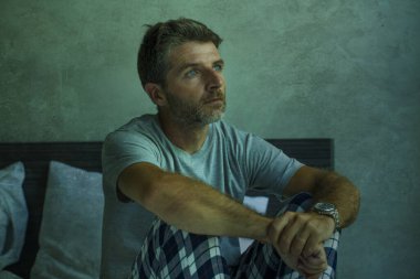 Çekici, korkmuş ve depresyonda olan 40 'lı yaşlarda pijamalı bir adamın dramatik portresi virüs karantinası sırasında endişe ve depresyon sorunu yaşıyor.
