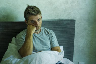 Çekici, korkmuş ve depresyonda olan 40 'lı yaşlarda pijamalı bir adamın dramatik portresi virüs karantinası sırasında endişe ve depresyon sorunu yaşıyor.