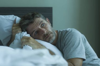 Çekici, korkmuş ve depresyonda olan 40 'lı yaşlarda pijamalı bir adamın dramatik portresi virüs karantinası sırasında endişe ve depresyon sorunu yaşıyor.