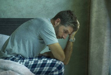 Çekici, korkmuş ve depresyonda olan 40 'lı yaşlarda pijamalı bir adamın dramatik portresi virüs karantinası sırasında endişe ve depresyon sorunu yaşıyor.
