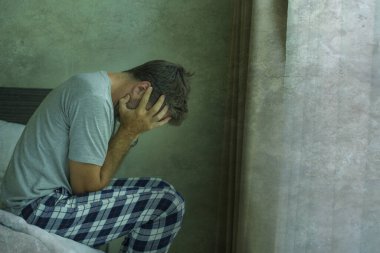 Çekici, korkmuş ve depresyonda olan 40 'lı yaşlarda pijamalı bir adamın dramatik portresi virüs karantinası sırasında endişe ve depresyon sorunu yaşıyor.