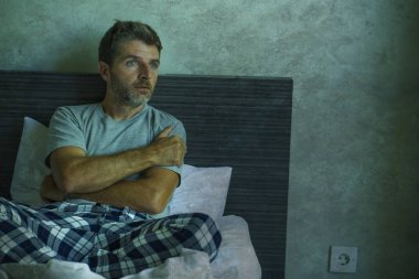Çekici, korkmuş ve depresyonda olan 40 'lı yaşlarda pijamalı bir adamın dramatik portresi virüs karantinası sırasında endişe ve depresyon sorunu yaşıyor.