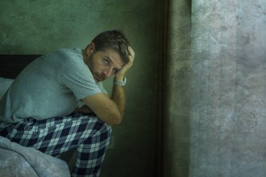 Çekici, korkmuş ve depresyonda olan 40 'lı yaşlarda pijamalı bir adamın dramatik portresi virüs karantinası sırasında endişe ve depresyon sorunu yaşıyor.