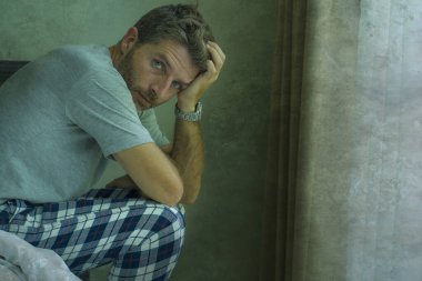 Çekici, korkmuş ve depresyonda olan 40 'lı yaşlarda pijamalı bir adamın dramatik portresi virüs karantinası sırasında endişe ve depresyon sorunu yaşıyor.