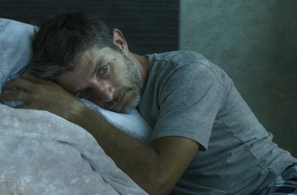 穿着睡衣躺在床上的40多岁的男子在被病毒性隔离的家庭中感到焦虑和抑郁的戏剧性画像 — 图库照片