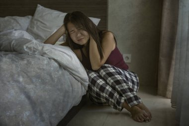 Depresyondaki ve üzgün Asyalı Koreli kadının dramatik karanlık portresi. Endişeli ve korkmuş. Depresyon sorunu ve yatağa yaslanma korkusu.