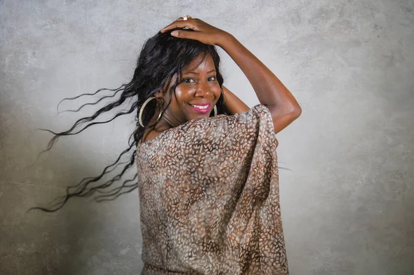 young stylish and happy black African American woman posing confident and playful isolated on grunge background looking at camera in cool and positive attitude smiling cheerful