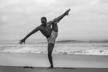 Çağdaş dans koreografı ve dansçısı, bale sahili egzersizi yapıyor. Genç, çekici ve atletik siyahi Afrikalı Amerikalı erkek dışarıda dans ediyor. Dramatik bir performans sergiliyor. 