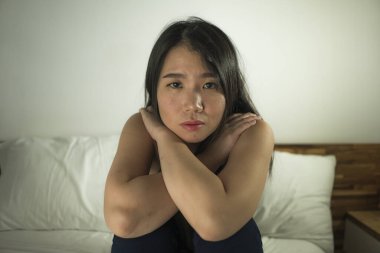 Çaresiz ve bunalımlı Asyalı genç bir kadının kapalı yatak portresi. Korkak ve bunalmış hisseden Çinli kadın. Tek başına ağlayan.