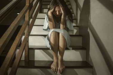 Depresyon geçiren genç ve çaresiz Çinli kadın ya da genç kızın Asya korku filmi tarzı portresi. Ya da evdeki merdivenlerde oturan umutsuz zihinsel bozukluk.