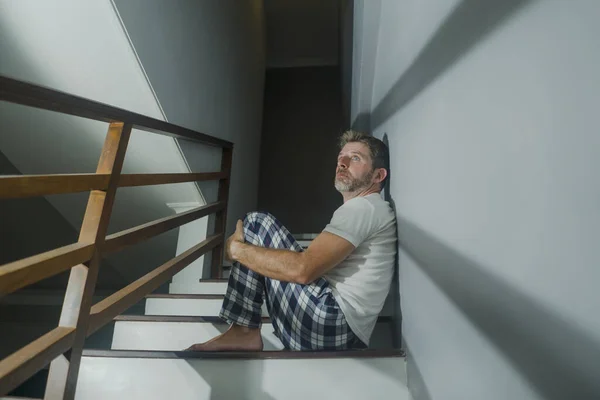 恐怖电影风格的肖像画 描写穿着睡衣 患有抑郁症或精神障碍的悲伤绝望的男人坐在家里绝望的楼梯上 绝望地哭泣 不知所措 — 图库照片