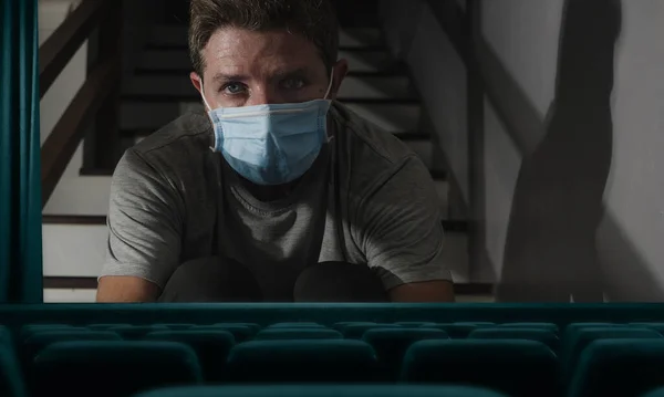 2020年Covid 19病毒爆发时空旷电影院放映电影的概念小说形象屏幕上的男子戴着防护面具被隔离在家里 — 图库照片