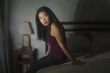 Korkak ve depresif Asyalı bir kadının dramatik yaşam tarzı portresi. Endişe ve depresyon yaşayan Koreli kadın. Yatakta panik içinde karantina evlerinin kilitlenmesi yüzünden ağlıyor.