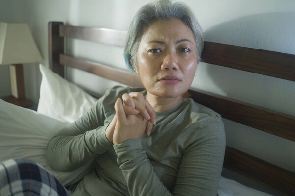 mature lady crisis - indoors lifestyle portrait of middle aged woman with grey hair sad and depressed in bed feeling frustrated and lonely thinking about aging lonely suffering depression 