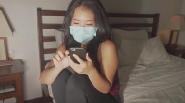 Covid-19 karantina evindeki tecrit - Korunma maskeli Asyalı genç ve güzel bir Çinli kadın Coronavirus salgınından endişe ediyor.