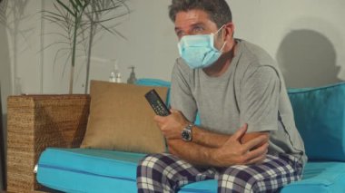 covid-19 virüs paniği - üzgün ve endişeli adam Coronavirus salgınıyla ilgili haberleri izlerken evde kalıp salgını kontrol altına almak için talimat aldı.