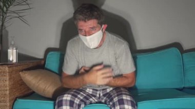 Covid-19 virüs enfeksiyonu belirtileri. Maskeli, korkmuş ve endişeli bir adam. Kanepede hasta, öksürüyor ve göğüs ağrısı çekiyor. 