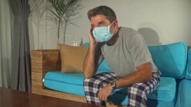 covid-19 virüs paniği - üzgün ve endişeli adam Coronavirus salgınıyla ilgili haberleri izlerken evde kalıp salgını kontrol altına almak için talimat aldı.
