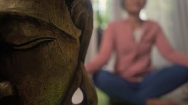 Ev hayatı. 50 'li yaşlarında güzel ve mutlu olgun bir kadın. Asya deco yatak odasında yoga yapıyor ve meditasyon yapıyor.