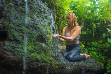 Açık havada, tropikal yağmur ormanlarında kayalıklarda yaşayan genç ve güzel bir kadının macera portresi. Yaz tatili boyunca tatlı ve tasasız bir şekilde doğanın tadını çıkarıyor.