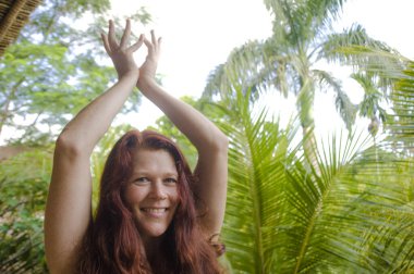 Çekici ve mutlu bir kadının doğal portresi. Yoga ve meditasyon yapıyor. Nilüfer pozisyonunda, bambu kulübesinde oturuyor.