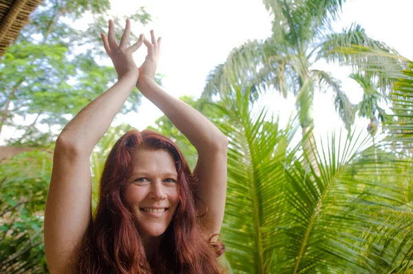 Çekici ve mutlu bir kadının doğal portresi. Yoga ve meditasyon yapıyor. Nilüfer pozisyonunda, bambu kulübesinde oturuyor.