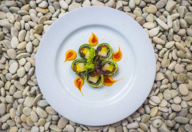 Japon gurme mutfağı - lezzetli ve narin Japon suşi yemeği geleneksel sağlıklı Asya yemekleri ve yaratıcı doğulu yemek kavramının taş zemin üzerinde yuvarlanıyor.