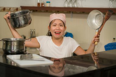 Ev işlerinde hayal kırıklığına uğramış genç Asyalı kadın. Mutfakta çalışan, mutsuz ve üzgün Japon bir kızın hayat tarzı portresi.