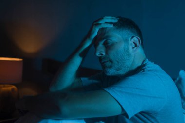 Karamsar, depresif ve endişeli bir adamın dramatik portresi. Depresyon krizi ve kaygı yaşıyor. Uykusuzluk ve hayat sorunu kavramında uykusuz oturuyor.